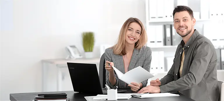 Frau und Man sitzen am Tisch, vor Ihnen ein Laptop